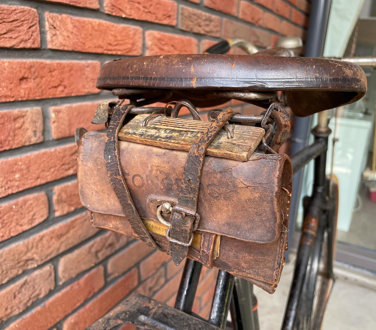 Een onaangeroerd Fongers zadeltasje met een houten plankje waar de naam van de eerste eigenaar nog op staat