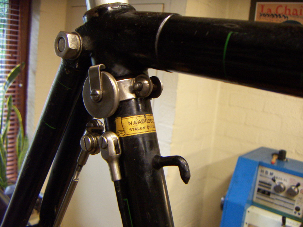 Het schroefje aan de voorkant van het frame, ook weer gezien op de beeldbankfoto`s. Ik zelf zou de schroef aan de achterkant van de zadelbuis hebben gezet