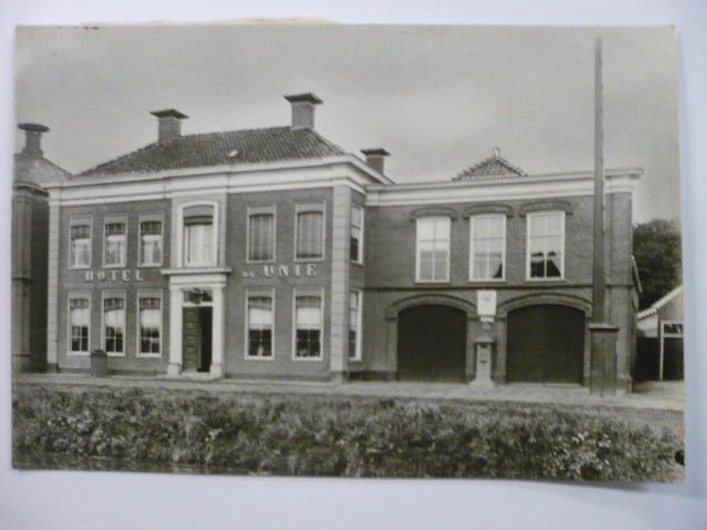 Foto van de in de negentiende eeuw gestichte Hotel “De Unie” aan het Boven-Oosterdiep 131 te Veendam, Later werd het ook wel, naar de nieuwe eigenaar, “Hotel Eerkes” genoemd. In 19 I 7 werd in dit grote pand met rechts de ingangen voor de koetsen naar de stalruimte , de rijwiel- en radiogroothandel R. L. de Graaff N. V. gevestigd.